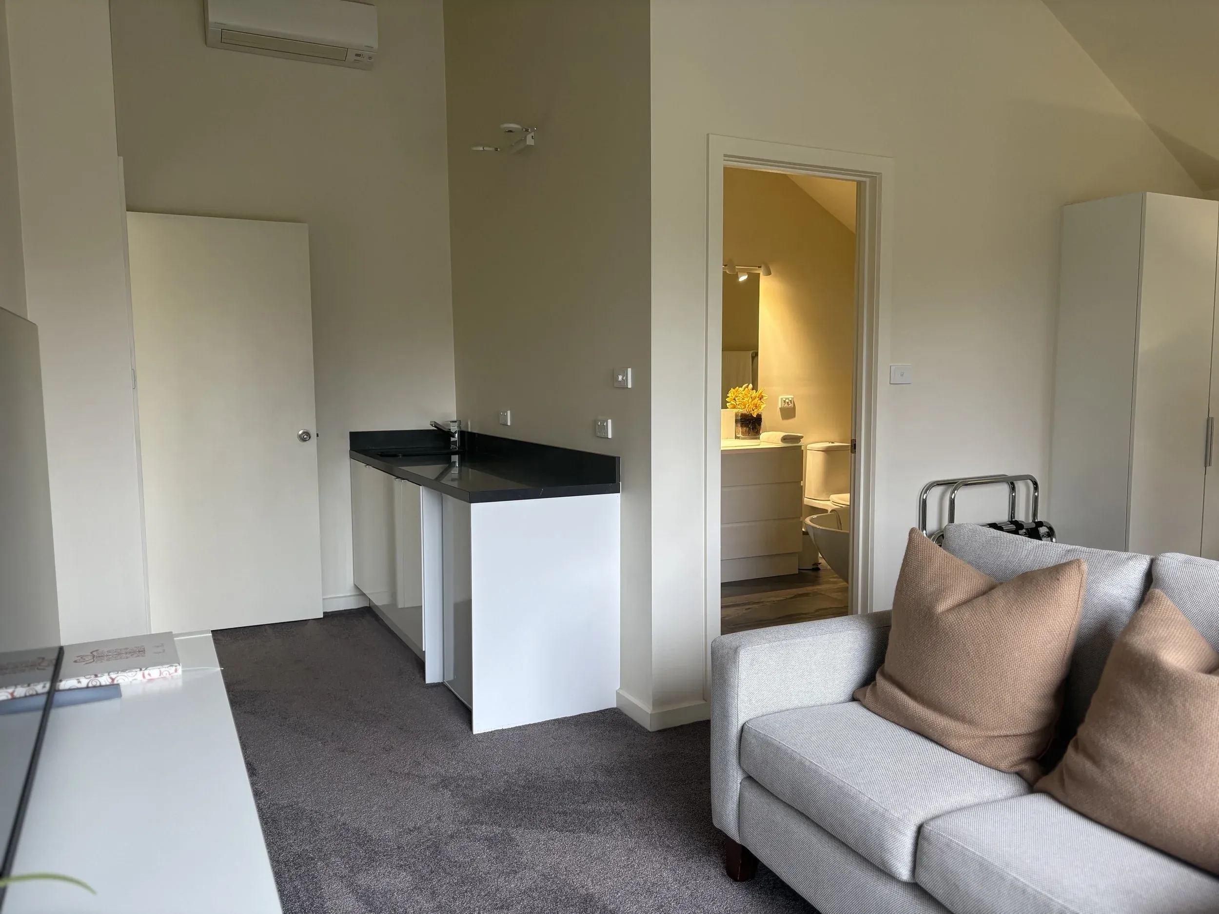 Villa living area with armchairs and bathroom beyond